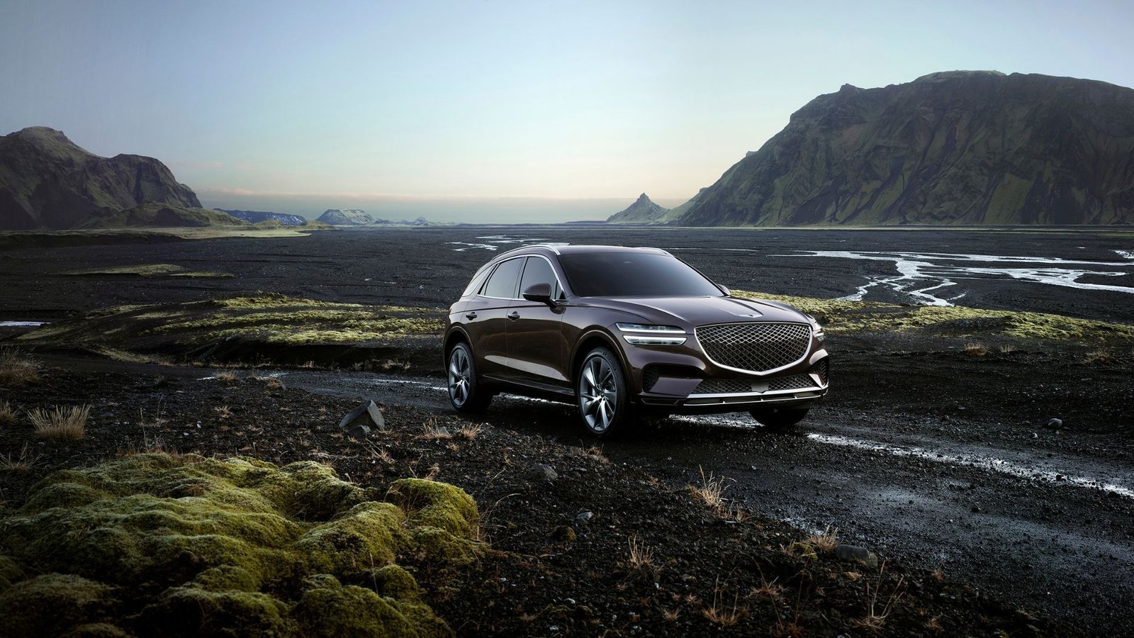 Static front 3/4 shot of a Genesis GV70 off-roading.