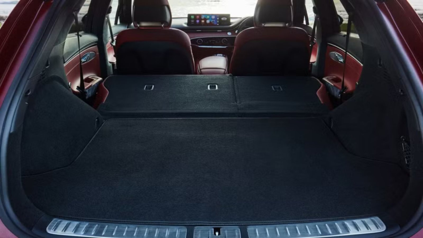 Close-up shot inside of the trunk of a Genesis GV70, with the rear seats folded down showing the expansive cargo space.