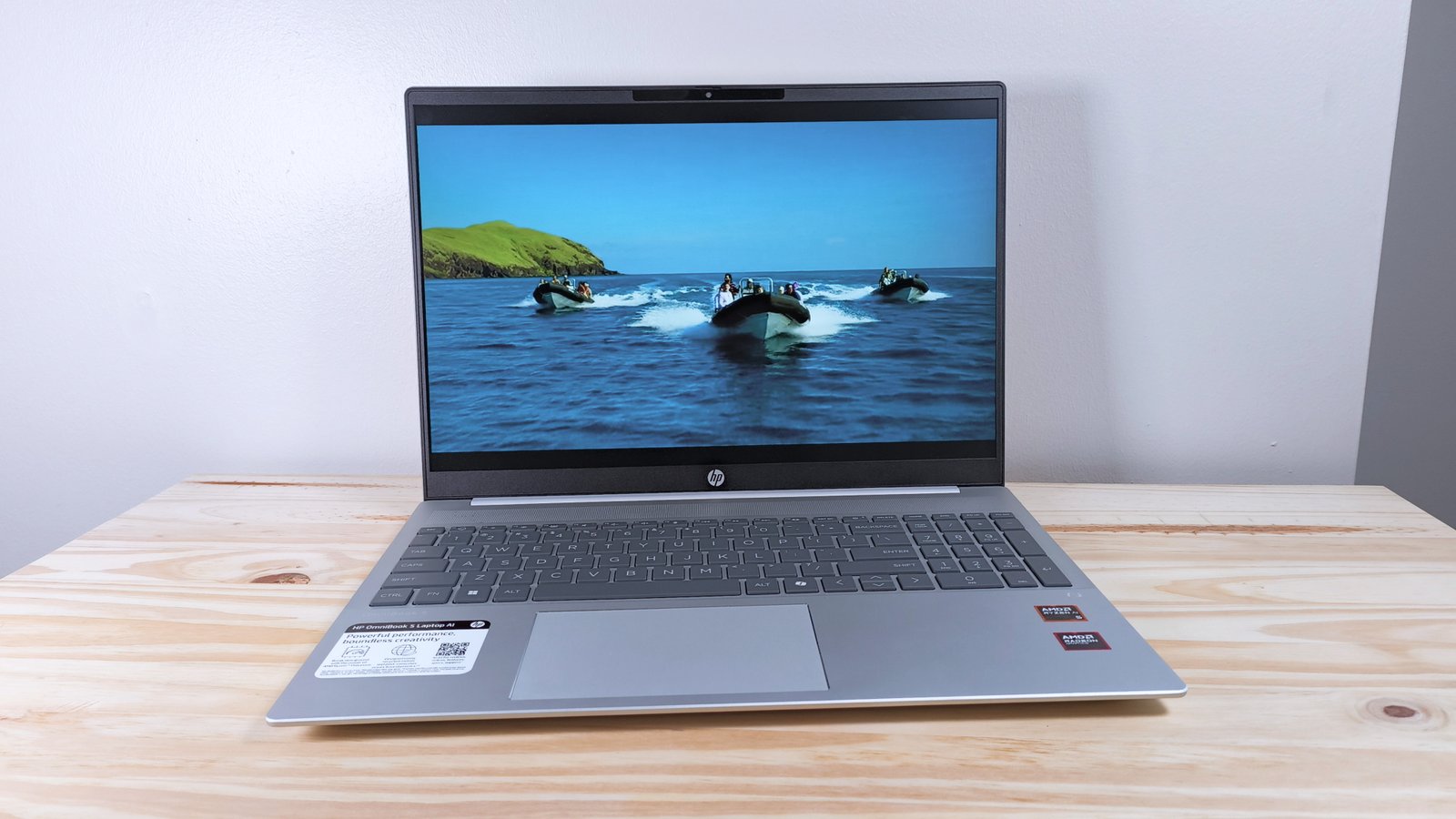 The HP Omnibook 5 Laptop AI on a wood table playing an episode of